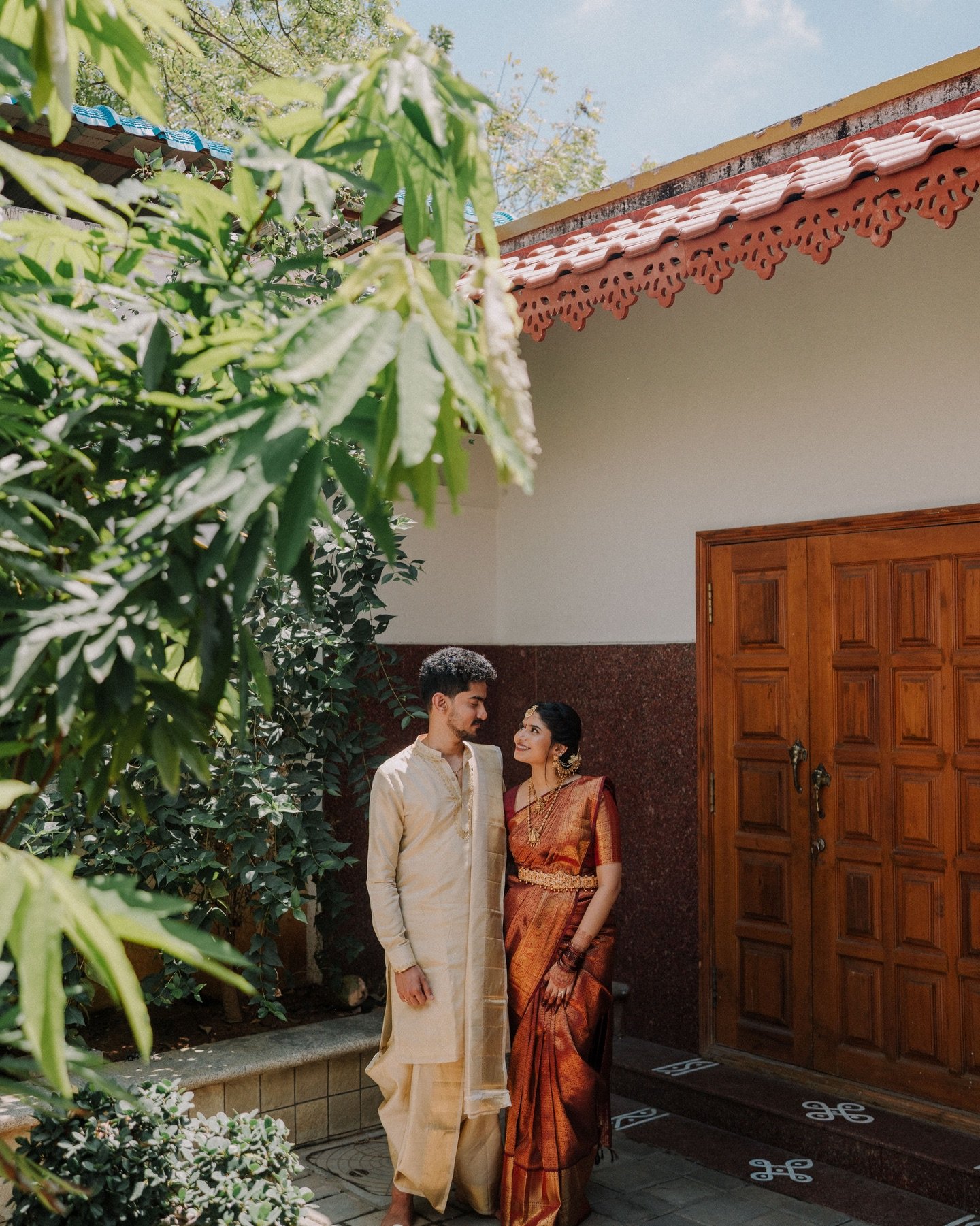 A couple sharing a quiet look outside a traditional home